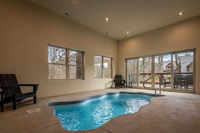 Indoor swimming pool room with loungers and glazing to the deck